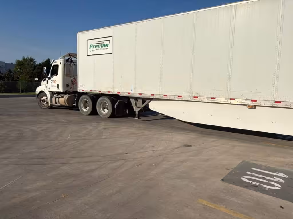 Zelo Express truck moving a white Premier trailer to demonstrate effective Dwell Time Reduction strategies