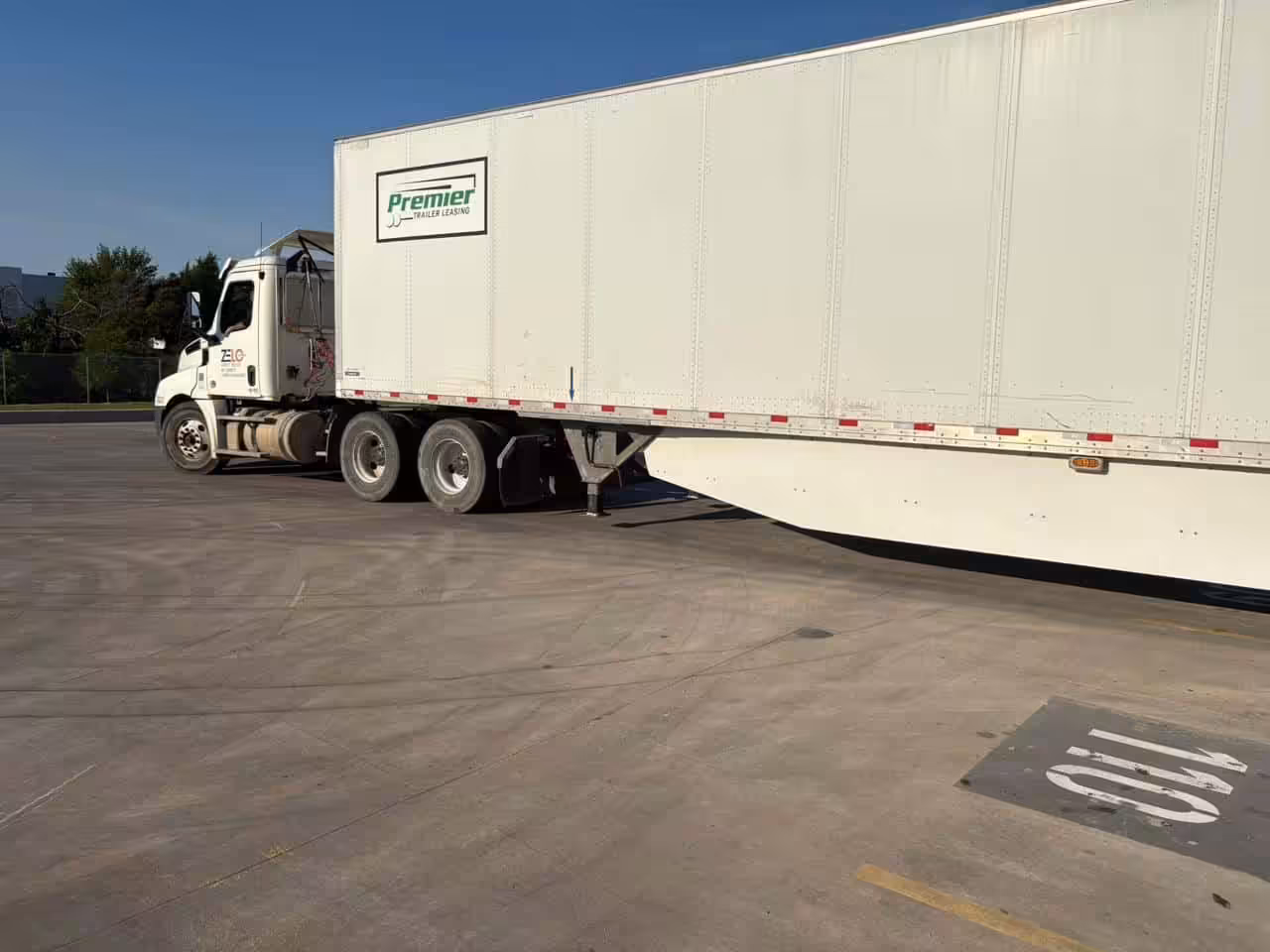 Zelo Express truck moving a white Premier trailer to demonstrate effective Dwell Time Reduction strategies