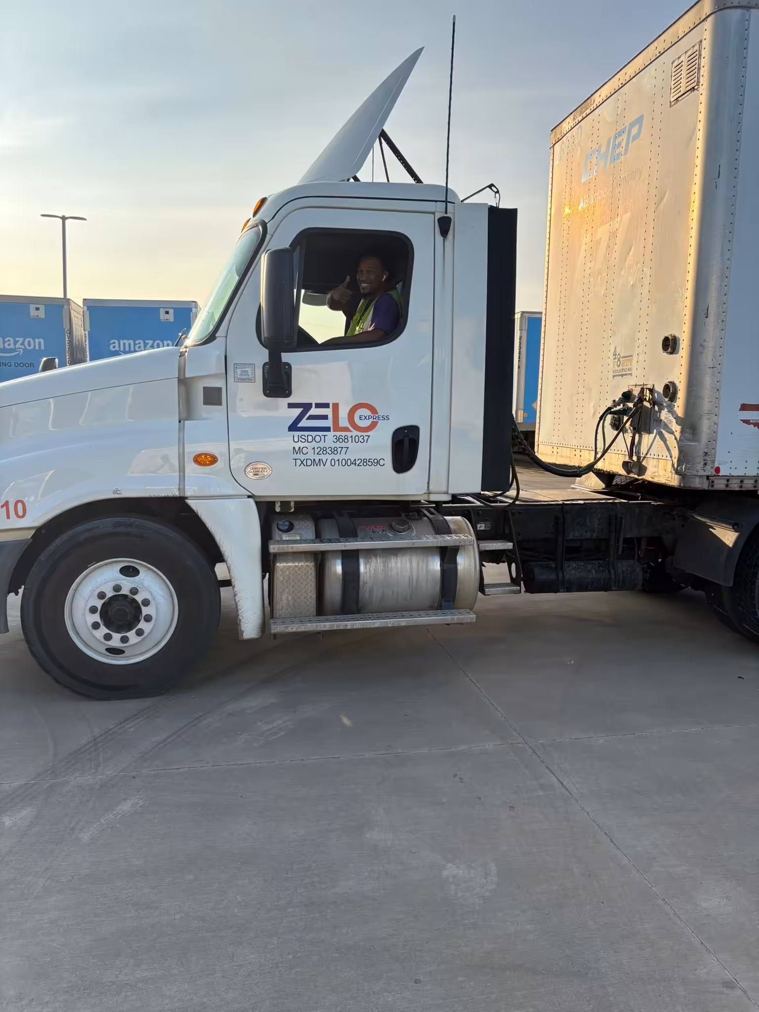 Driver giving a thumbs up from a Zelo Express truck cab highlighting dwell time reduction