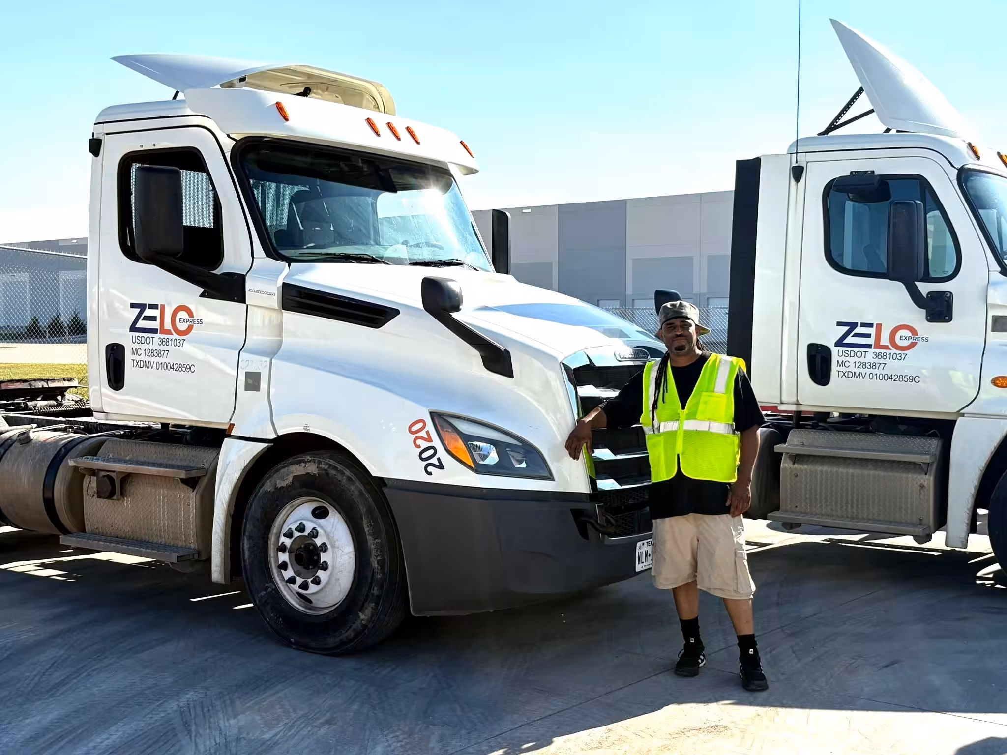 Professional driver standing by a Zelo Express truck representing a veteran-owned yard logistics company